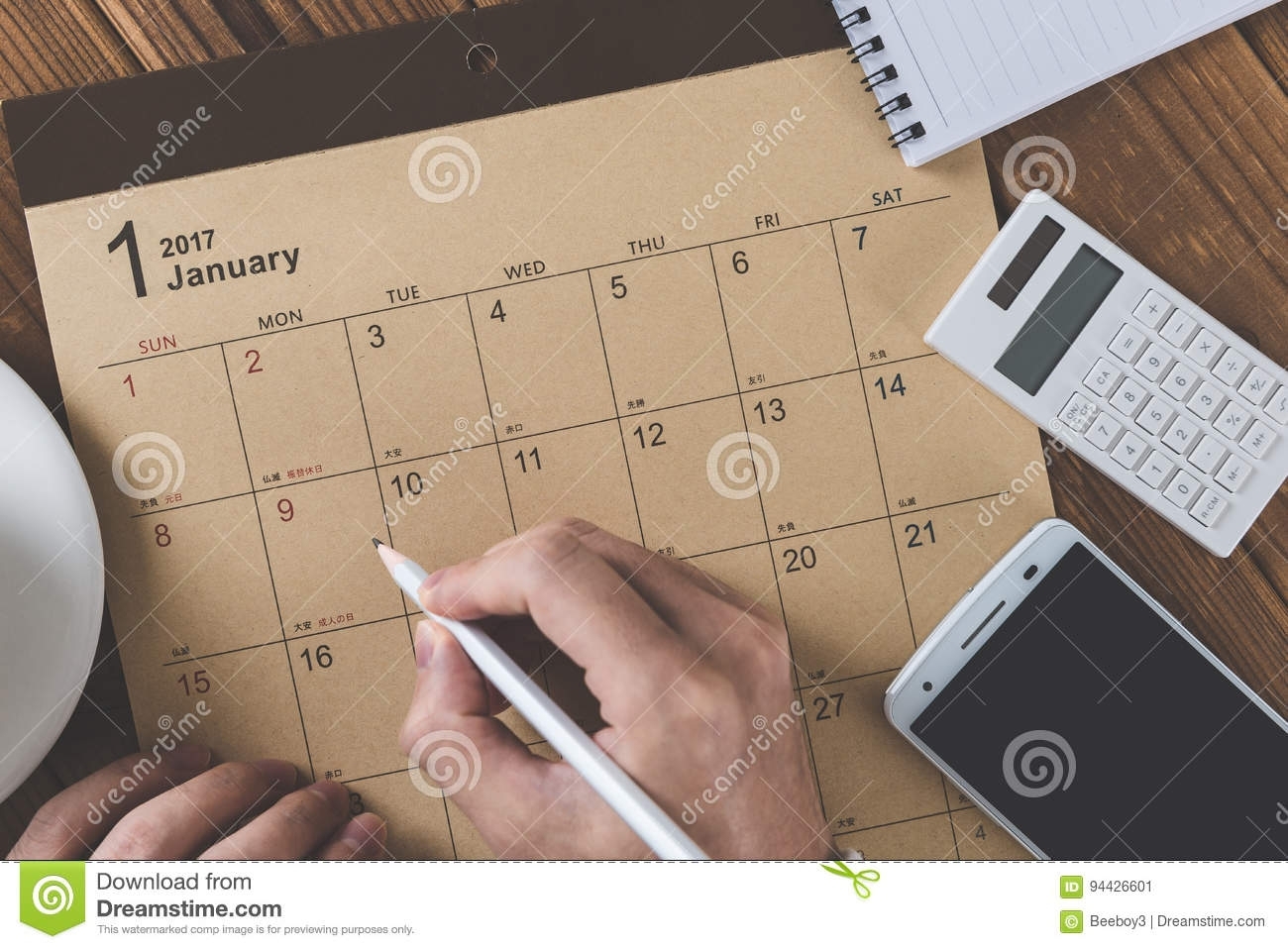 Write A Schedule To A Calendar Placed On A Wooden Table